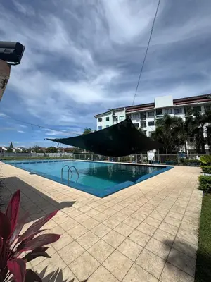 a large swimming pool in front of a building at D88Staycations 104 - Condo near Enchanted Kingdom in Santa Rosa