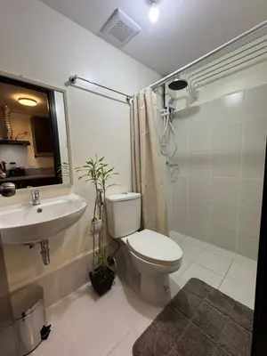 a bathroom with a toilet and a sink and a shower at The Fresh Escape 2 in Manila