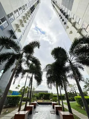 a view of a building with palm trees and benches at The Fresh Escape 2 in Manila