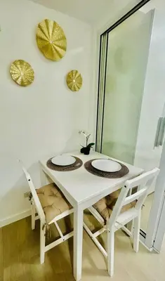 a white table with two chairs and a dog under it at SM Bicutan by Bahamas in Manila