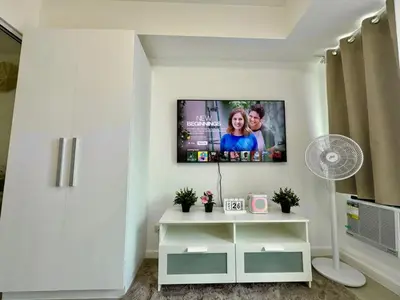 a living room with a flat screen tv on a wall at SM Bicutan by Bahamas in Manila