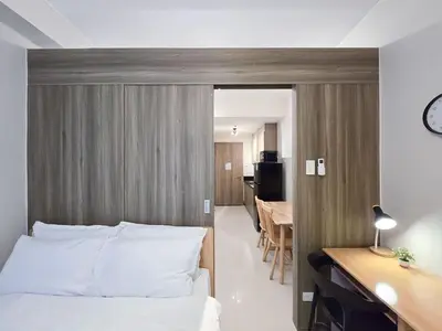 a bedroom with a bed and a desk and a room at 1BR Condotel with Balcony at FAME Residences #FM32-1 in Manila