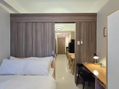 a hotel room with a bed and a desk and a room at 1BR Condotel with Balcony at FAME Residences #FM33-1 in Manila