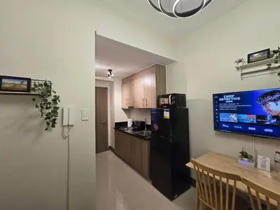 a kitchen with a black refrigerator and a table at 1BR Condotel with Balcony at FAME Residences #FM33-1 in Manila