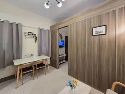 a room with a table and a wooden wall at 1BR Condotel with Balcony at FAME Residences #FM34-1 in Manila
