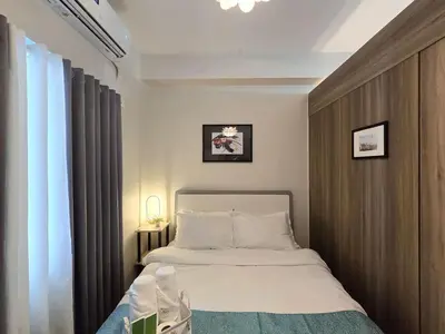 a small bedroom with a bed and a window at 1BR Condotel with Balcony at FAME Residences #FM34-1 in Manila