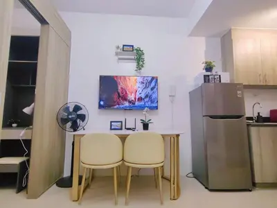 a kitchen with a table and two chairs and a refrigerator at 1BR Condotel with Balcony at FAME Residences #FM36-1 in Manila