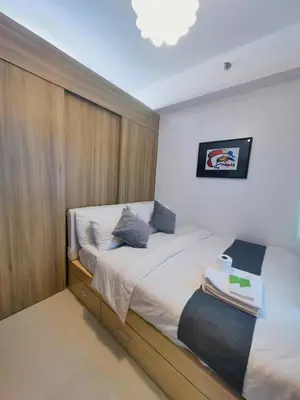 a bedroom with a bed with a wooden wall at 1BR Condotel with Balcony at FAME Residences #FM36-1 in Manila