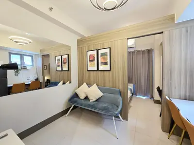 a living room with a blue chair and a table at 1BR Condotel with Balcony at FAME Residences #FM35-1 in Manila