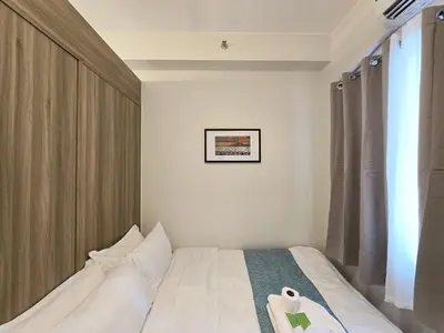 a bedroom with a bed and a window at 1BR Condotel with Balcony at FAME Residences #FM35-1 in Manila