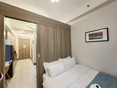 a bedroom with a white bed in a room at 1BR Condotel with Balcony at FAME Residences #FM35-1 in Manila