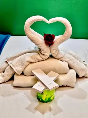 a towel animal made to look like swans on a bed at Comfystay at Sea Residences in Manila