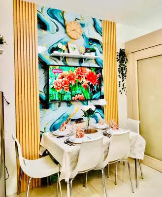 a dining room with a table with white chairs at Comfystay at Sea Residences in Manila