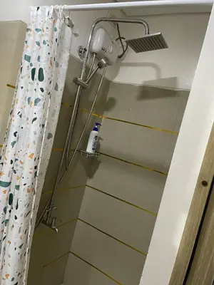 a shower in a bathroom with a shower curtain at Walking Distance to Mall of Asia - Spacious Condo with Hot Shower and Balcony in Manila