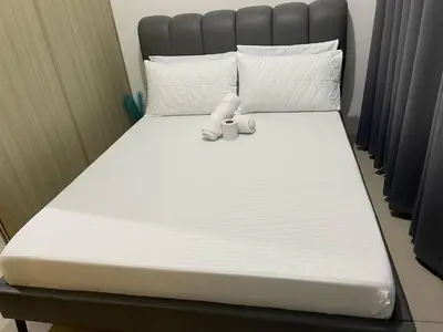 a bed with white sheets and two cups on it at Walking Distance to Mall of Asia - Spacious Condo with Hot Shower and Balcony in Manila