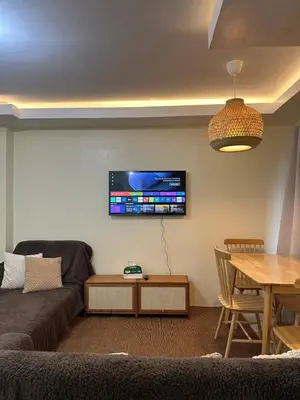 a living room with a couch and a tv on the wall at MAINE'S STAYCATION at Enchanted Kingdom in Santa Rosa