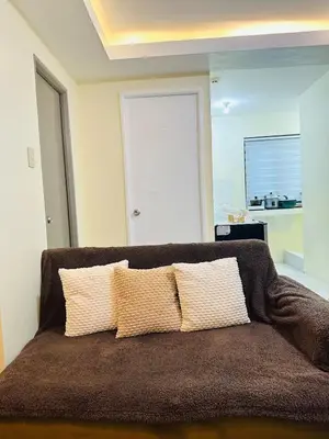 a couch with two pillows on it in a room at MAINE'S STAYCATION at Enchanted Kingdom in Santa Rosa