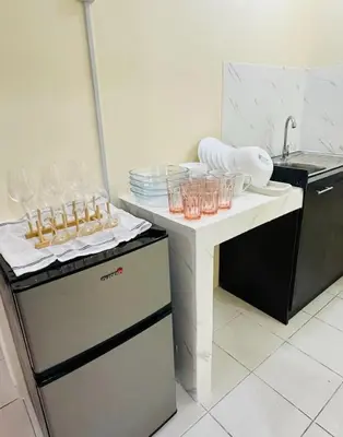 a kitchen with plates and glasses on a counter at MAINE'S STAYCATION at Enchanted Kingdom in Santa Rosa