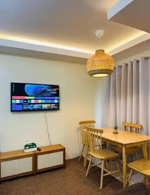 a dining room with a table and chairs and a tv at MAINE'S STAYCATION at Enchanted Kingdom in Santa Rosa