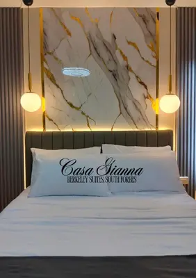 a bedroom with a bed with a marble wall at Casa Gianna at Berkeley Suites, South Forbes in Silang