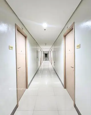 a corridor of an empty hallway with two doors at Blooming Friends Retreat in Manila