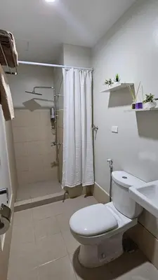 a white bathroom with a toilet and a shower at Blooming Friends Retreat in Manila