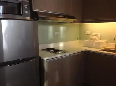 a kitchen with a stove and a refrigerator at Makati 1BR High Floor in Manila