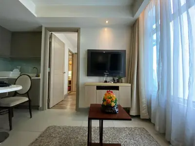 a living room with a television and a table at Makati 1BR High Floor in Manila
