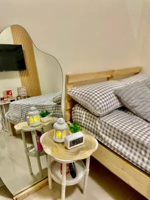 a bedroom with two beds and two tables at The Cozy Fabb in Manila