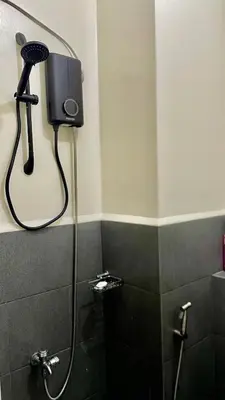 a shower in a bathroom with a blow dryer at The Cozy Fabb in Manila