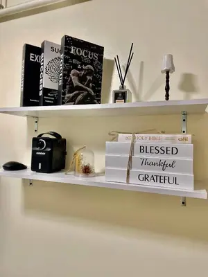 a shelf with books and a clock on it at The Cozy Fabb in Manila