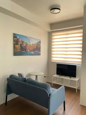 a living room with a couch and a television at Warm Modern Condo Apartment with Pool & Balcony - East Residences Ortigas Pasig City in Manila