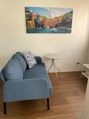 a living room with a blue couch and a table at Warm Modern Condo Apartment with Pool & Balcony - East Residences Ortigas Pasig City in Manila