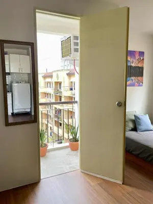 an open door to a room with a bed and a window at Warm Modern Condo Apartment with Pool & Balcony - East Residences Ortigas Pasig City in Manila