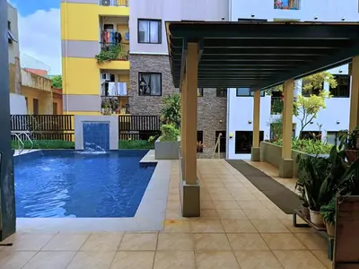 a swimming pool in the middle of a building at Warm Modern Condo Apartment with Pool & Balcony - East Residences Ortigas Pasig City in Manila
