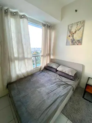 a bed in a room with a window at Spacious 2br condo at Quezon City Mezza Residences 1 in Manila