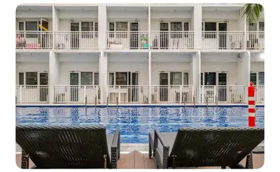 a hotel with a swimming pool and two chairs at Porongs Oasis in Manila
