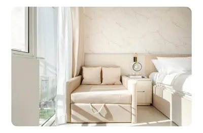 a bedroom with a bed and a chair next to a window at Porongs Oasis in Manila
