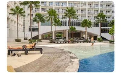 a man laying on a bench in front of a building at Porongs Oasis in Manila