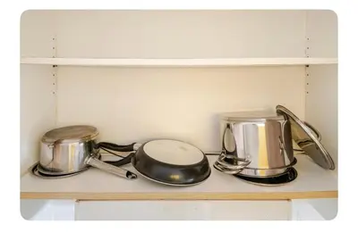 two pots and pans on a shelf in a kitchen at Porongs Oasis in Manila