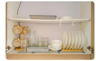 a shelf with plates and utensils in a kitchen at Porongs Oasis in Manila