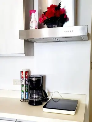 a kitchen counter with a coffee maker on a shelf at Azurejulz Dream Staycation in Manila