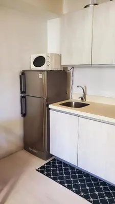 a small kitchen with a sink and a refrigerator at Azurejulz Dream Staycation in Manila