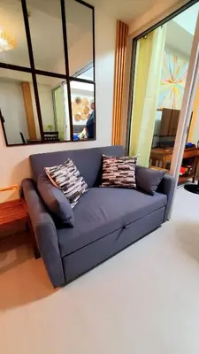 a blue couch in a living room with a mirror at Azurejulz Dream Staycation in Manila