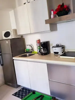 a small kitchen with a sink and a refrigerator at Azurejulz Dream Staycation in Manila