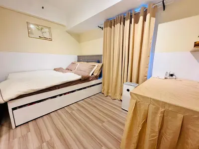 a small bedroom with two beds and a table at Cozy Vibes Retreat in Makati in Manila