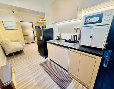 a kitchen with a sink and a refrigerator at Cozy Vibes Retreat in Makati in Manila
