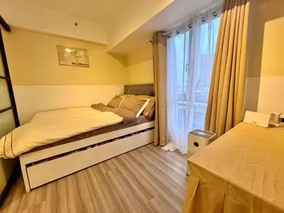 a bedroom with two beds and a large window at Cozy Vibes Retreat in Makati in Manila