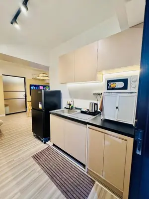 a kitchen with a black refrigerator and a counter top at Cozy Vibes Retreat in Makati in Manila