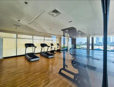 a gym with cardio equipment in a building at Cozy Vibes Retreat in Makati in Manila